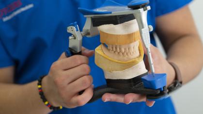 student holding dental mold